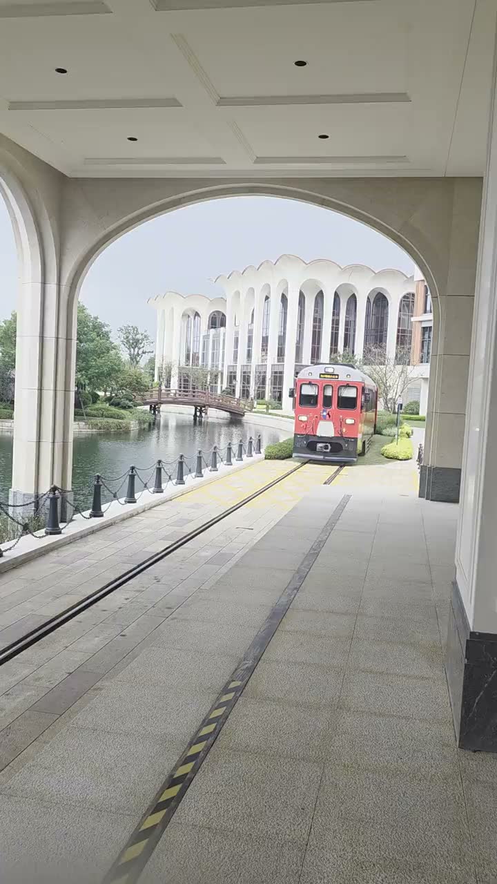 アーチ回廊の駅に入線する赤いキャンパス列車